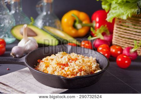 Homemade Vegetarian Couscous With Tomatoes, Carrots, Pepper On A Dark Kitchen Table With Vegetables 