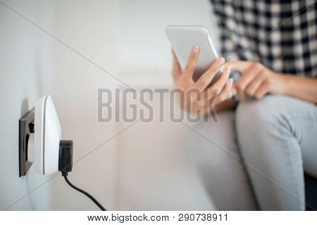 Woman Controlling Smart Plug Using App On Mobile Phone