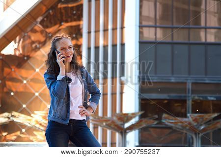 Happy Teen Girl Talk By A Mobile Phone Talk In A Large Metropolis