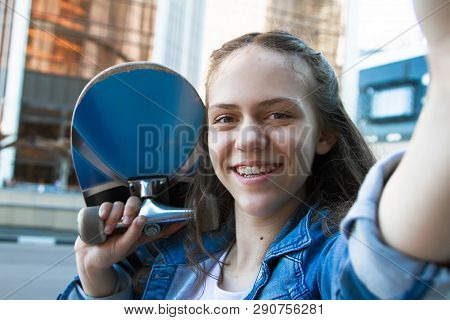 Selfie Photo Of Smiling Teen Girl Holding A Skateboard On Her Shoulder