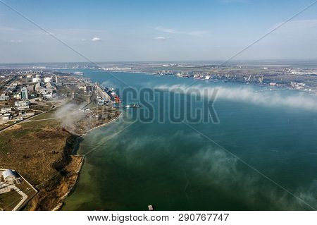 Aerial View Of Panoramic Seaport Warehouse And Container Ship, Crane Vessel Working For Delivery Of