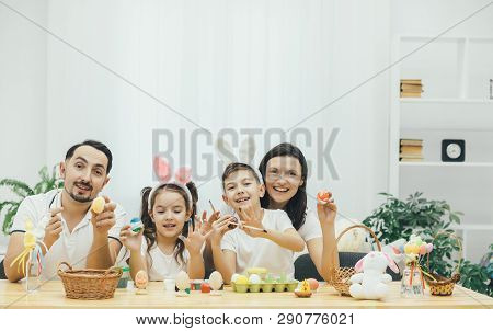Amicable Mother Father Son And Daughter Are Involved In The Process Of Preparing Fer Easter, Paintin
