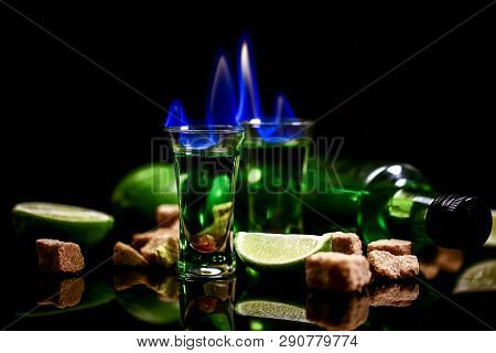 Absinthe In Glass With Lime Slices On Dark Background. Absinthe Poured Into A Glass.absinthe Poured 