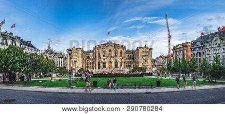 Oslo, Norway - August 3, 2018: People Walk And Relax In The Park Next To The Building Of The Norwegi