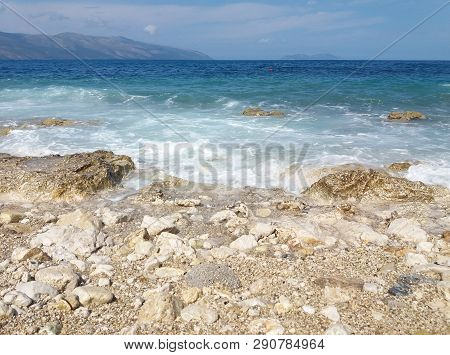 Summer Albania Beach View. Ionian And Adriatic Sea. Seashore With Wave Sand Rock Stone Sky And Sun. 