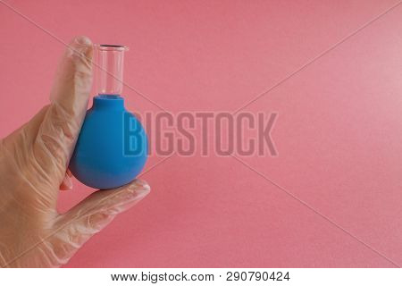 Female Hand With French Manicure In Medicine Glove Holds Blue Cosmetic Medical Jar For Vacuum Facial