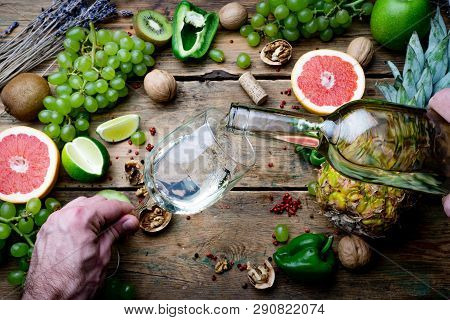Wine Maker Pouring Young White Bio Wine For Tasting With Grapes, Nuts And Fruit On The Old Wooden Ta