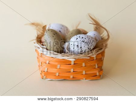 Easter Little Eggs With Feathers In Basket On Yellow Spring Background. Easter Concept.