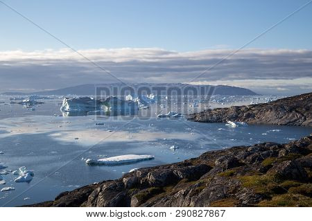 Ilulissat, Greenland - July 9, 2018: The Coastline And Icebergs During Midnight Sun. Rodebay, Also K