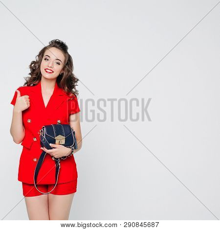 Beautiful Woman In Red Suit And Bag Showing Thumb Up.