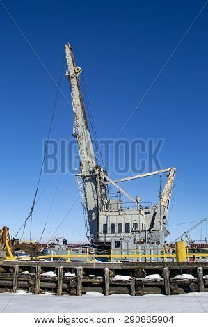 Grey Crane In Port. Winter Industrial Landscape