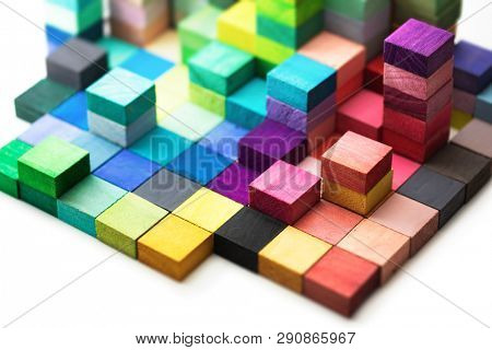 Spectrum of stacked multi-colored wooden blocks. Background or cover for something creative, diverse, expanding,  rising or growing. shallow depth of field.