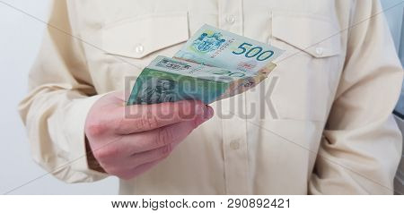 A Man Standing Wearing Light Colored Official Shirt Holds In His Hand Serbian Paper Money Of 20 And 