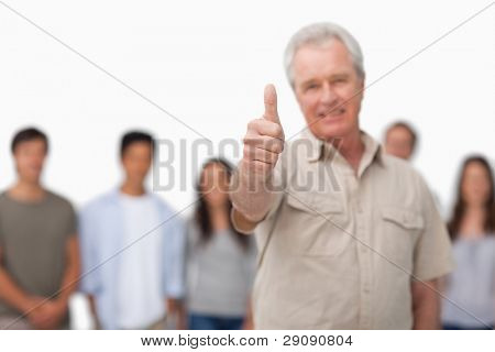 Pollice su dato da uomo maturo con i giovani dietro di lui contro uno sfondo bianco