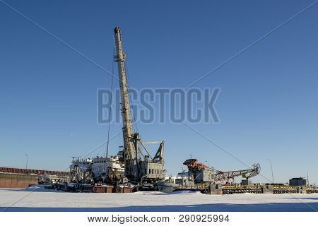 Grey Crane In Port. Winter Industrial Landscape