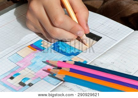 Child Hand Draws The Multicolored Minecraft Picture. Outdoors Close-up Horizontal Image
