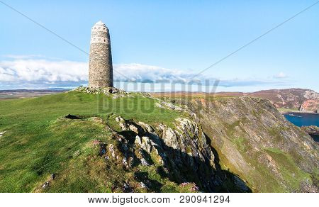 A Large Rock Tower Sits On A Grassy Field At The Tip Of The Oa Peninsula On The Island Of Islay In S