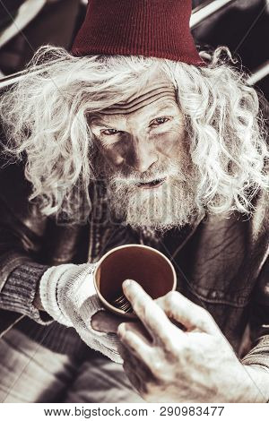 Caucasian Almsman Holding Cup With Money And Showing His Daily Income.