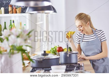 The Girl At The Table In The Kitchen With A Glass Of Orange Jui