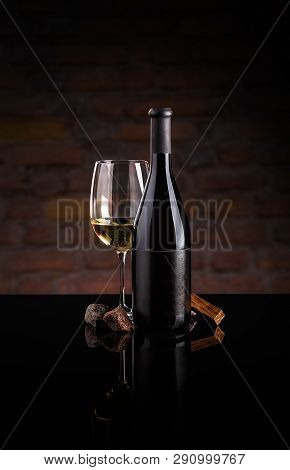 Glass Of Wine And Wine Bottle. Wine Testing Concept On Dark Background
