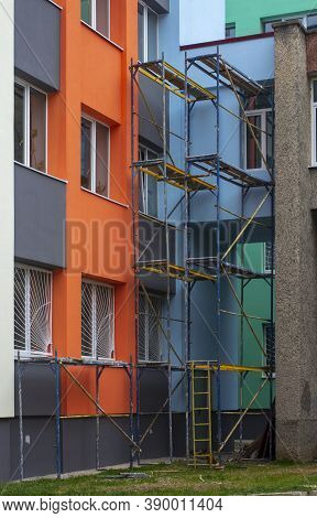 Scaffolding. Insulation Of The Facade With Foam. Wall Painting. Vertical Image.