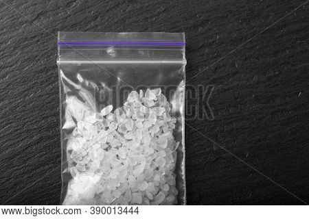 White Crystals Drugs Methamphetamine In A Plastic Bag On A Black Background