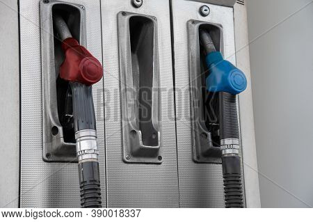 Pistols With Gasoline At The Gas Station. The Pistol Is Missing In The Middle.
