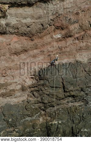Climbers Rappelling In A Cliff In The Special Natural Reserve Of Guigui.