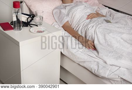 Bedside Table With Medicines And Water. The Papacy Is Self-isolating At Home.girl With  Cold At Home
