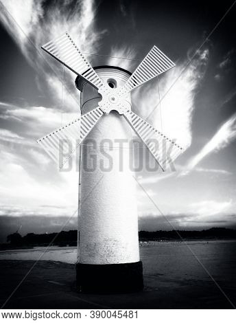 White Windmill By Sea On Rocky Coast. Seascape And Landscape
