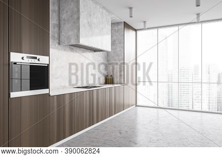 Corner Of Modern Kitchen With White And Dark Wooden Walls, Concrete Floor And Dark Wooden Cupboards.
