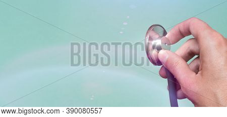 Female Hand Holds A Stethoscope On A Blue Background. Concept Doctor, Doctors Appointment, Virus, Tr