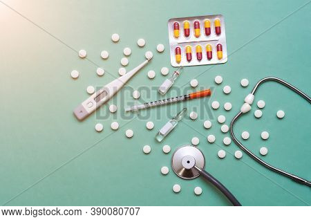 Pills, Ampoule, Syringes, Capsules, Stethoscope On The Green Doctor S Table.