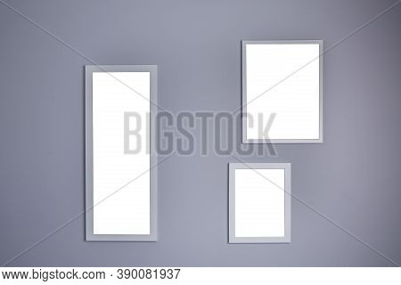 Poster Mockup With Three Frames On Empty Grey Wall