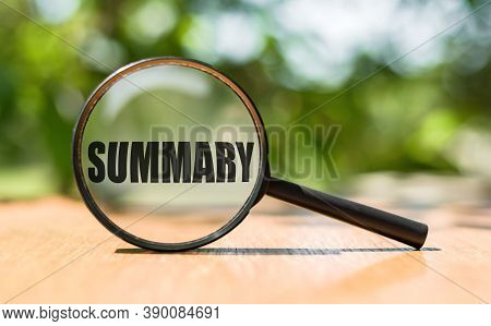 The Word Summary On Magnifier Glass On Wooden Table. Business Concept.