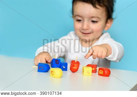 Little Jewish Boy Playing With Colorful Wood Dreidel. Selective Focus On Dreidel.