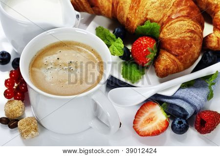 Desayuno con café, croissant y bayas frescas