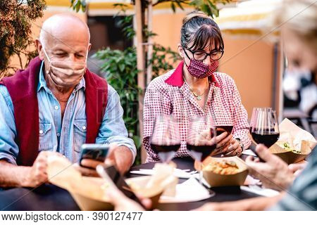 Senior People Using Mobile Smart Phone With Face Mask Covered - Retired Adults Worried While Watchin