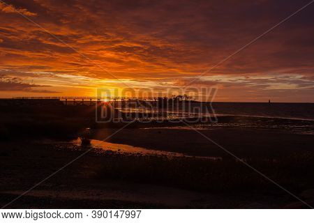 Fishing pier silhouette with sunris yellow colored sky