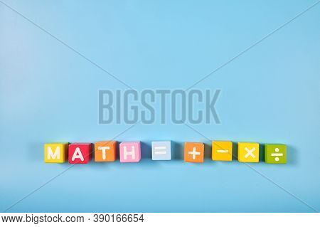 Flat Lay, Top View Of Bright Colored Math Symbols On Wooden Blocks On Blue Color Background With Cop