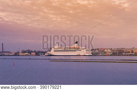 Passenger Ferry In The Port Of Riga. The Big Cruise Liner Near To Embankment At Sunset.