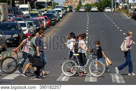 Bucharest, Romania - July 23, 2020: People cross the street near \