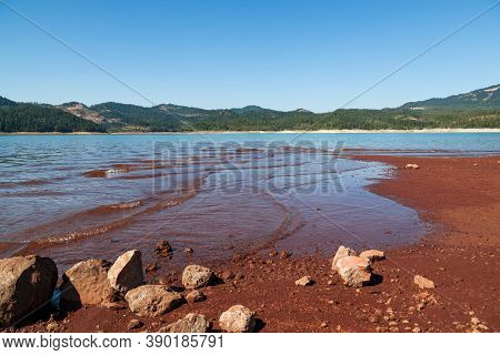 Low Water Levels Reveal Red Clay And Rocks At Lost Creak Lake Near Prospect, Oregon Located In The C
