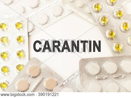 Word Carantin Written On A White Piece Of Paper. Pills And Vitamins Lie Nearby