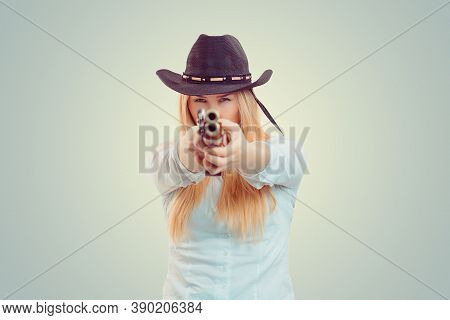 Woman In Cowboy Hat Aiming At Camera With Double-barreled Gun On Light Green Yellow Background. Conc