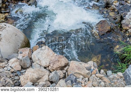 Top Down View Of Water Pouring Through Culvert From Mountain River.
