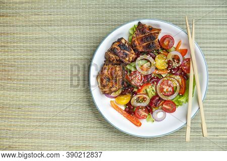 Pan-asian Sesame Salad Plate And Grilled Chicken Pieces In Pad Thai Sauce On A Bamboo Tablecloth And