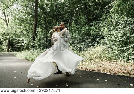 Just Married Couple Dancing Valse Outdoors, Free Space. Bride And Groom Hug, Blurred Green Grass Bac