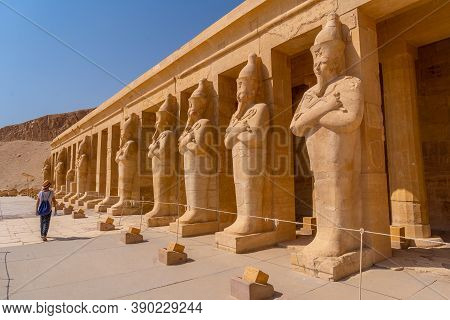 A Young Woman With Pharaoh Sculptures Entering Hatshepsut's Funerary Temple In Luxor. Egypt