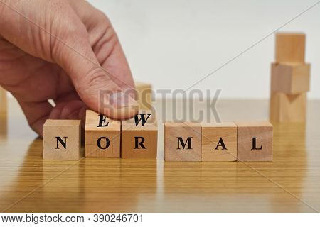 Hand Flipping Wooden Block Cubes For New Normal Wording. Adapting To New Life Or Business Post-lockd